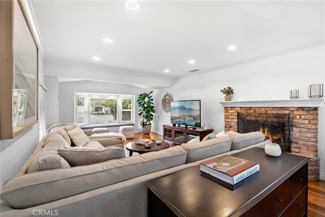 living room featuring visible vents, dark wood-type flooring, crown molding, recessed lighting, and a fireplace