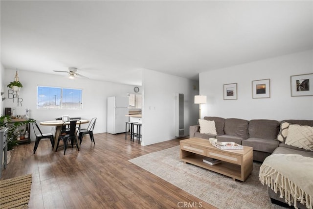 living room featuring baseboards, a ceiling fan, and wood finished floors