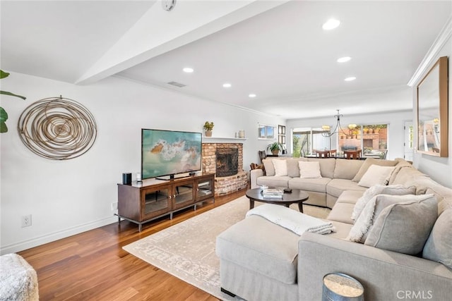 living area with wood finished floors, visible vents, baseboards, a fireplace, and recessed lighting