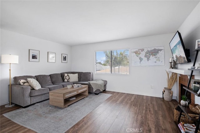 living room with dark wood-style floors, a fireplace, and baseboards