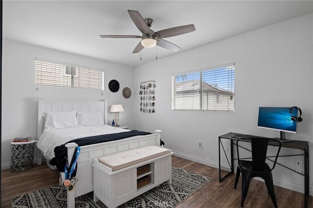 bedroom featuring baseboards, multiple windows, wood finished floors, and a ceiling fan