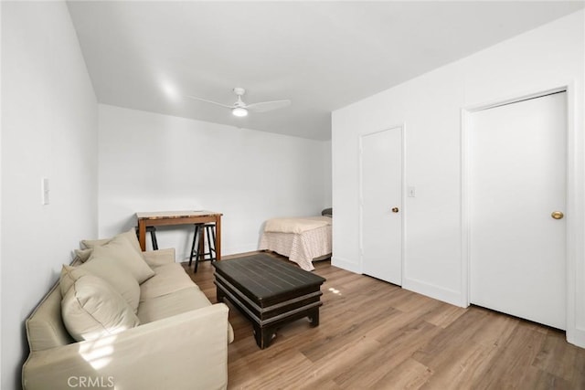 sitting room with wood finished floors and a ceiling fan