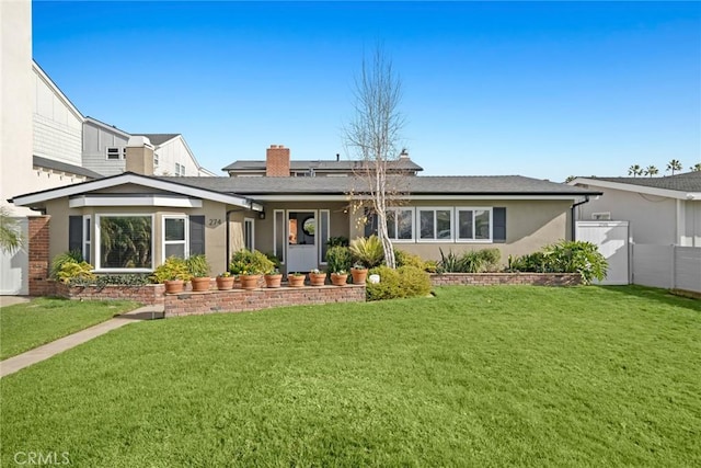 back of property featuring a yard, stucco siding, and fence