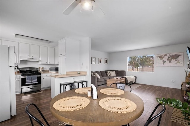 dining room with dark wood finished floors, baseboards, and ceiling fan