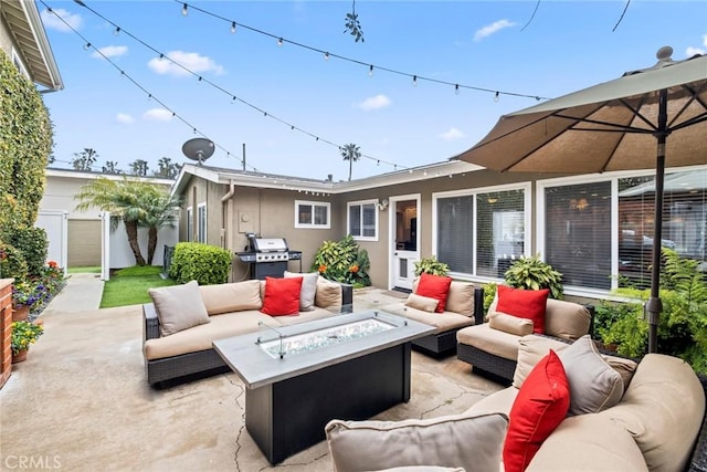 view of patio with a grill and an outdoor living space with a fire pit