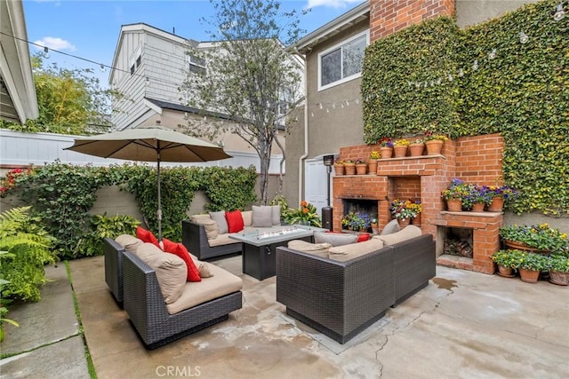 view of patio / terrace featuring an outdoor living space with a fireplace and fence