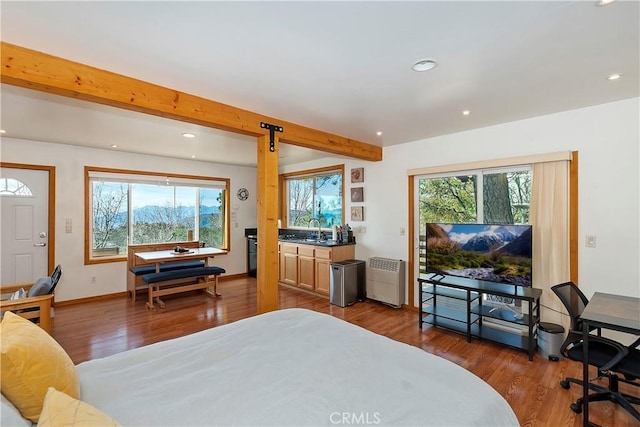 bedroom with dark hardwood / wood-style floors, sink, and beam ceiling