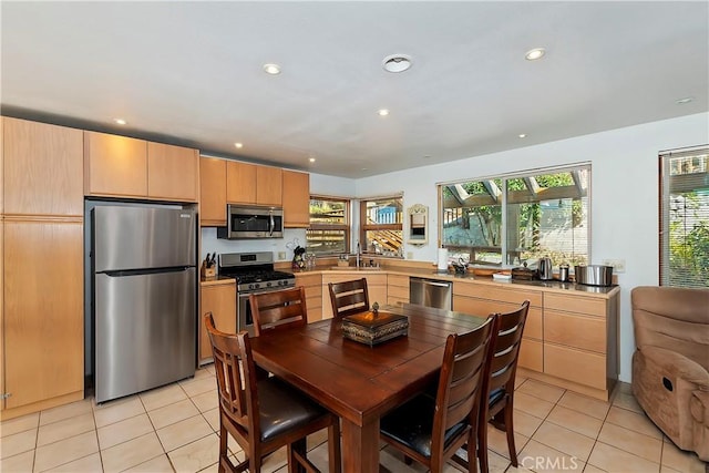 kitchen featuring appliances with stainless steel finishes, light brown cabinetry, sink, and light tile patterned floors