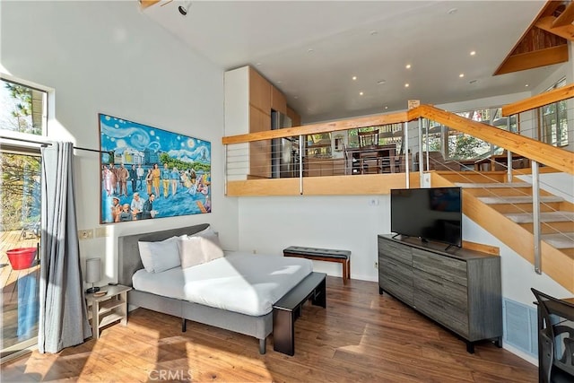 living area with hardwood / wood-style flooring and a high ceiling