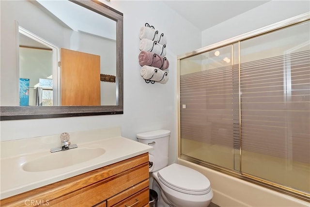 full bathroom with vanity, enclosed tub / shower combo, and toilet