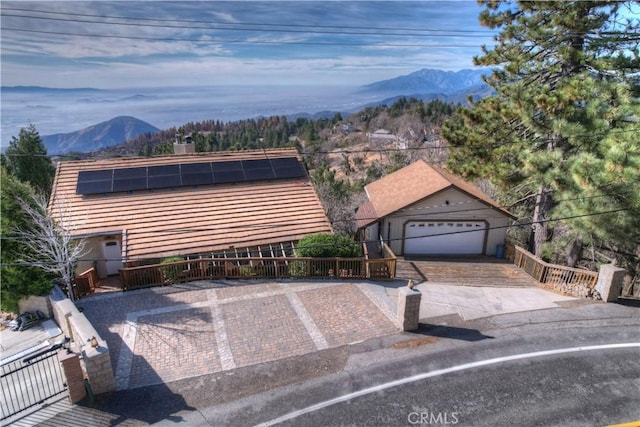 view of front of property with a mountain view and solar panels