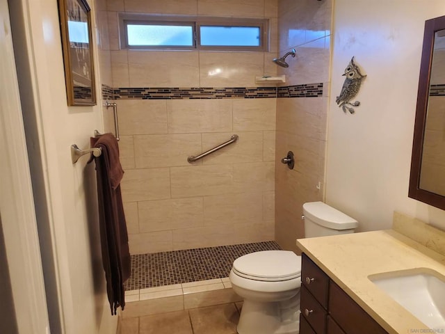 bathroom featuring tile patterned floors, vanity, toilet, and a tile shower