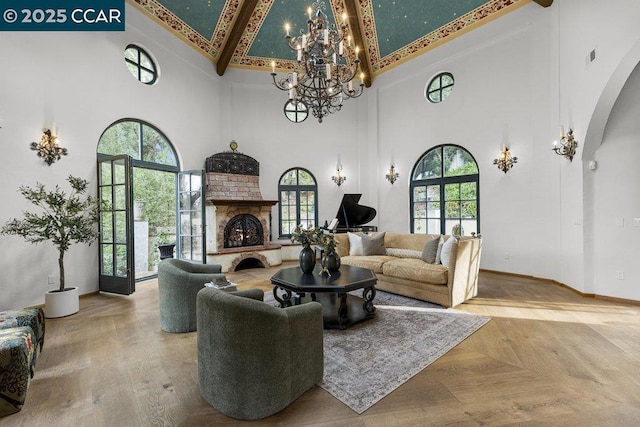 living room featuring a notable chandelier, beam ceiling, parquet flooring, and a high ceiling