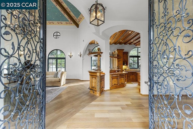 entryway with light hardwood / wood-style flooring, beamed ceiling, and plenty of natural light