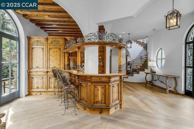 bar featuring pendant lighting and light hardwood / wood-style flooring