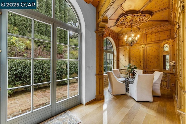 interior space with high vaulted ceiling, a chandelier, a wealth of natural light, and light wood-type flooring