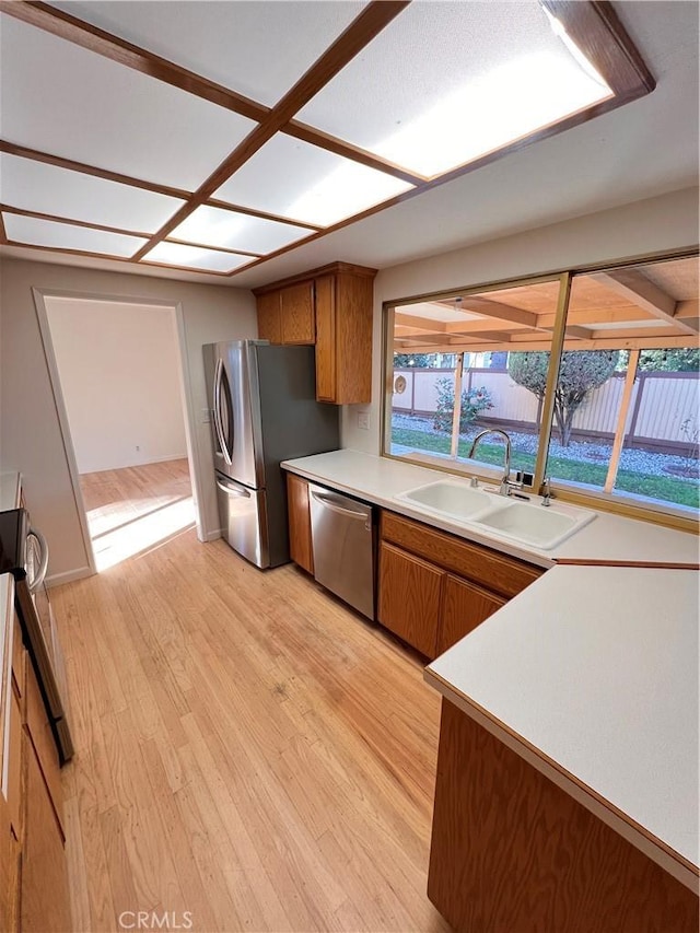 kitchen featuring stainless steel appliances, sink, and light wood-type flooring