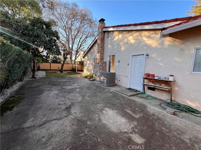 view of property exterior with central air condition unit and a patio area