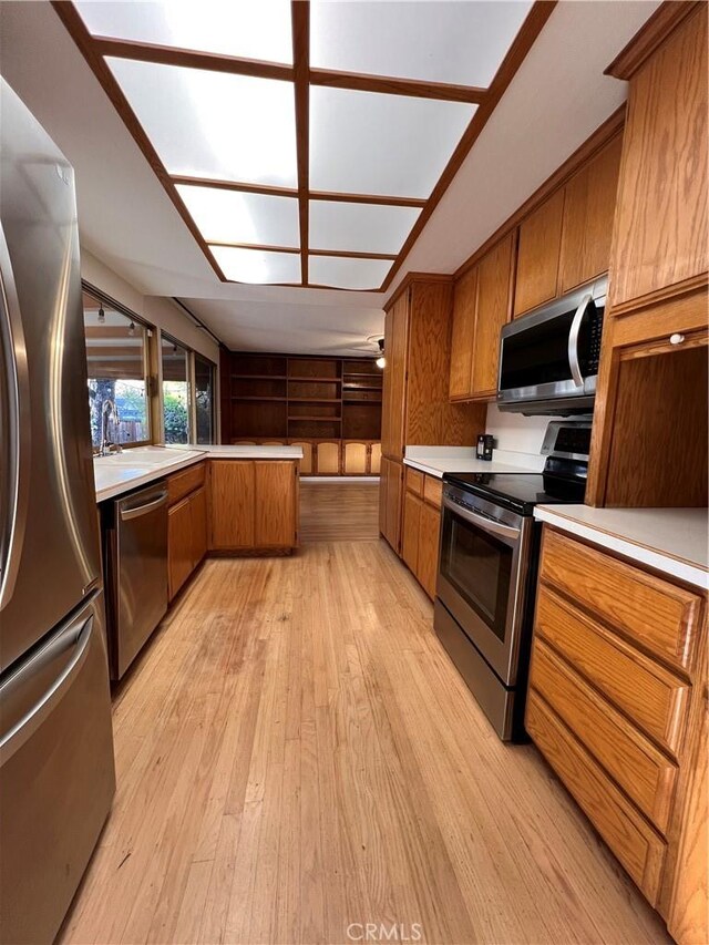 kitchen featuring stainless steel appliances, sink, and light hardwood / wood-style floors