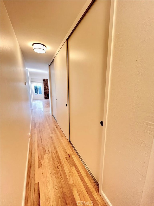 corridor with light hardwood / wood-style flooring