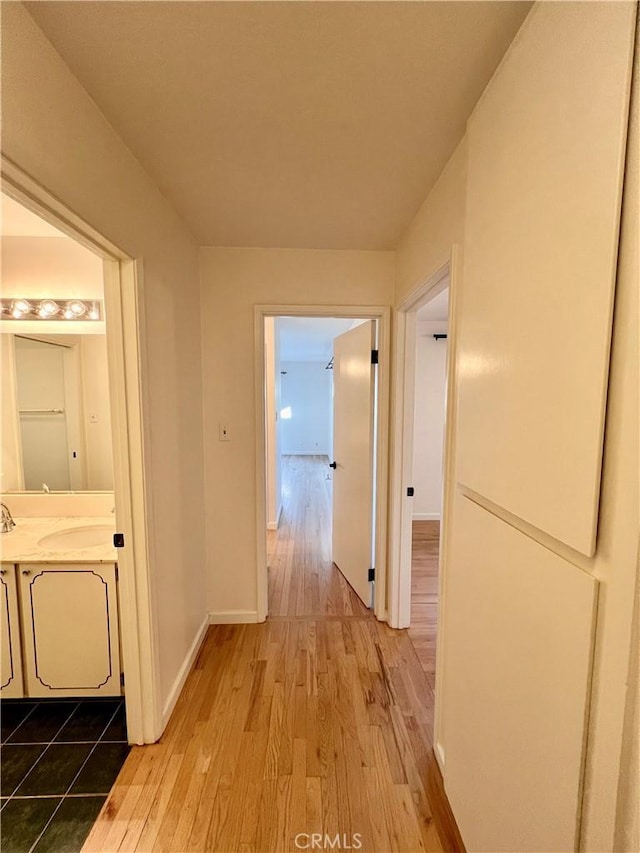 hallway with sink and light hardwood / wood-style floors