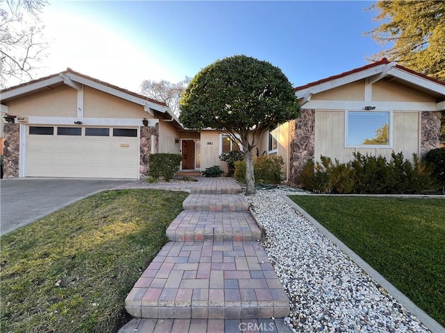 single story home featuring a garage and a front lawn