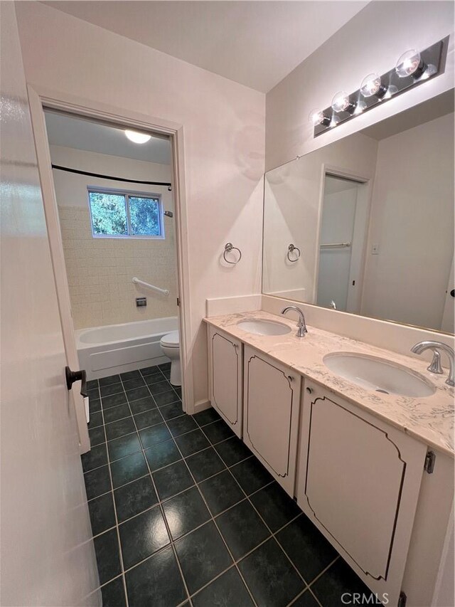 full bathroom featuring tile patterned floors, vanity, toilet, and tiled shower / bath combo