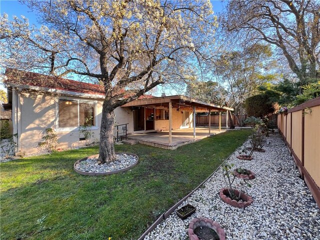 rear view of house featuring a yard and a patio area