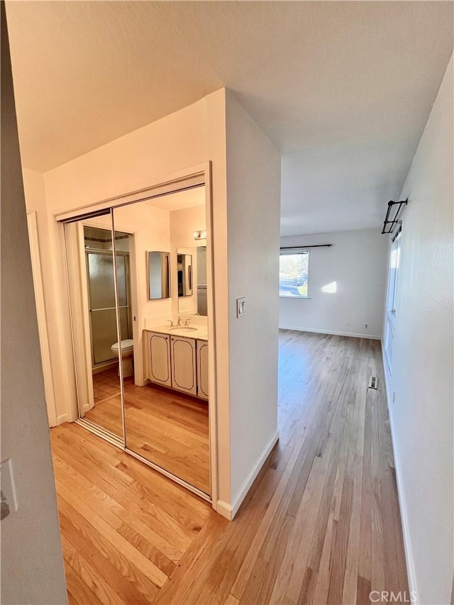 hallway featuring sink and light hardwood / wood-style floors