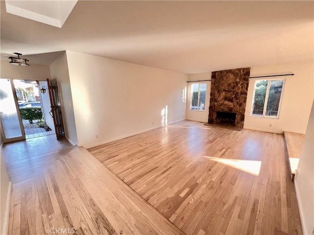 unfurnished living room featuring a fireplace and light hardwood / wood-style floors