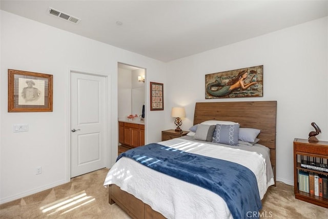 bedroom featuring connected bathroom and light carpet