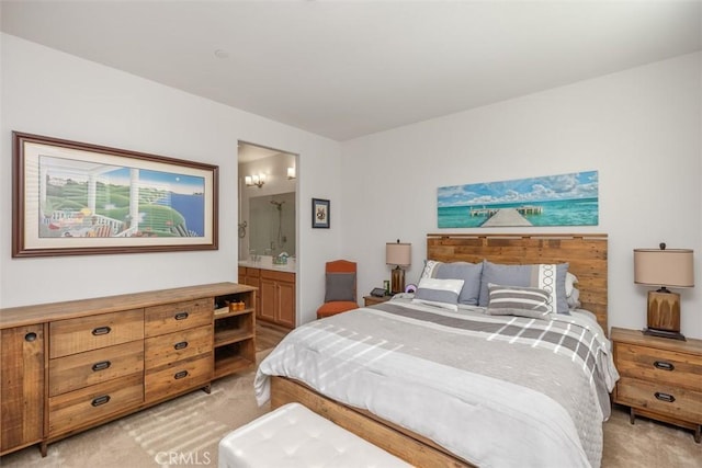 bedroom featuring light colored carpet and ensuite bath