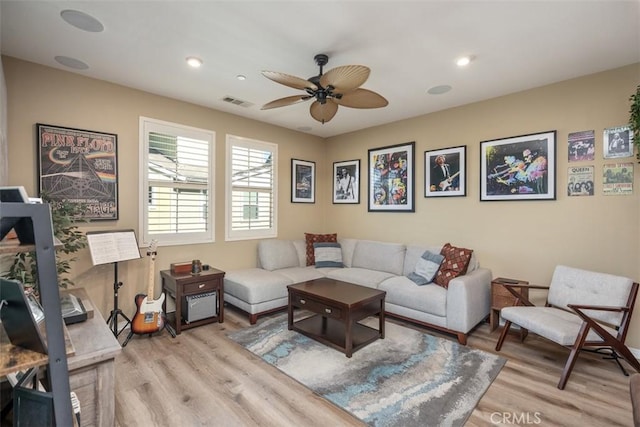 living room featuring ceiling fan and light hardwood / wood-style floors