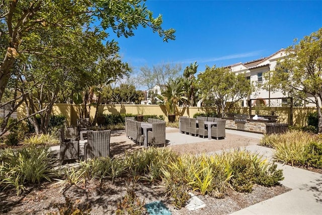 view of community with a patio, area for grilling, and an outdoor bar