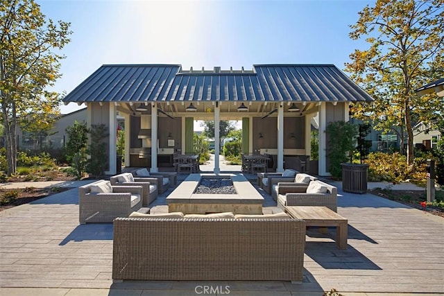 view of patio / terrace with a wooden deck, an outdoor living space with a fire pit, and ceiling fan