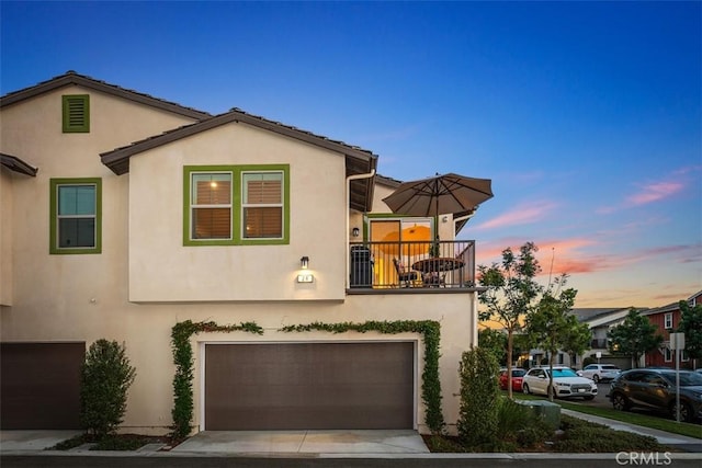 view of front of home with a garage and a balcony