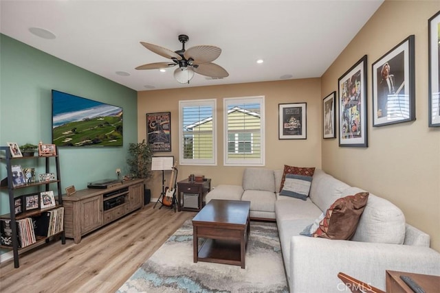 living room with ceiling fan and light hardwood / wood-style flooring