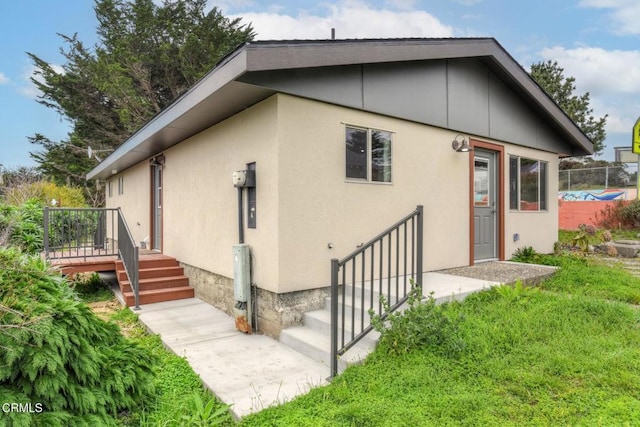 back of property featuring stucco siding