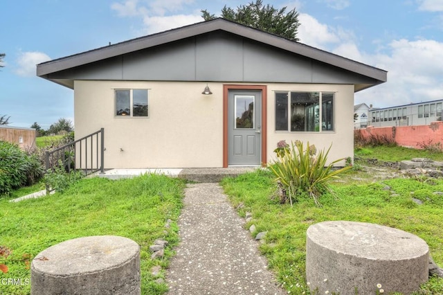 back of property featuring fence and stucco siding