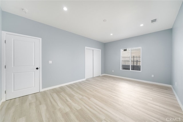 unfurnished bedroom featuring light hardwood / wood-style flooring and a closet