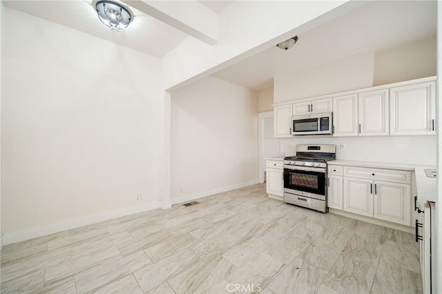 kitchen featuring appliances with stainless steel finishes, beam ceiling, and white cabinets