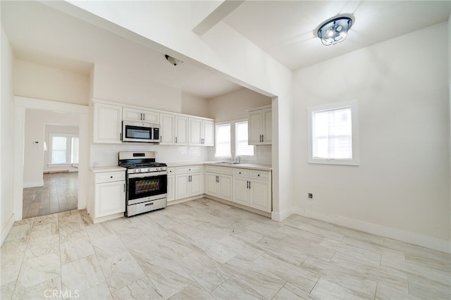 kitchen featuring white cabinetry, appliances with stainless steel finishes, sink, and backsplash