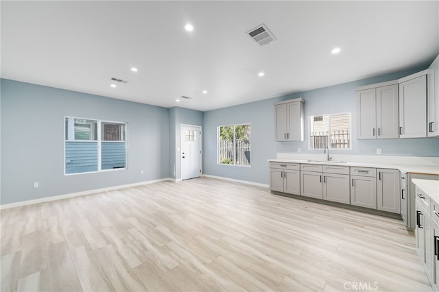 kitchen with light hardwood / wood-style flooring, sink, and gray cabinets