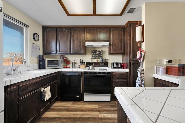 kitchen featuring sink, dishwasher, dark brown cabinetry, range with gas stovetop, and tile countertops