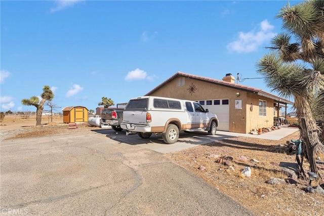 view of front of property featuring a shed and a garage