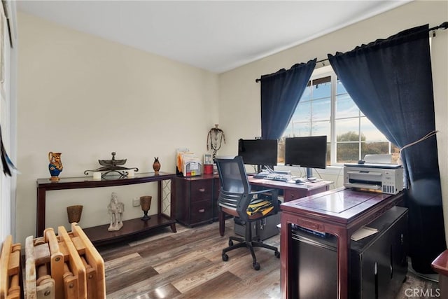 office area with radiator heating unit and hardwood / wood-style floors