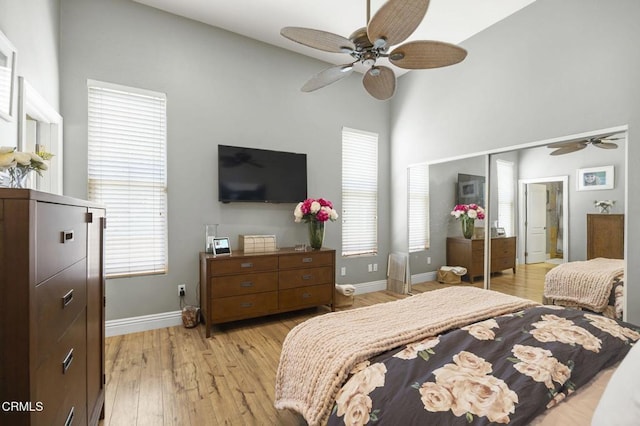 bedroom with light hardwood / wood-style floors, ceiling fan, and a closet