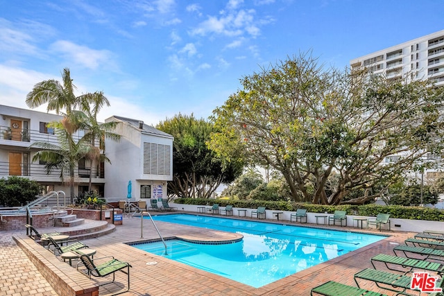 view of pool featuring a jacuzzi and a patio area