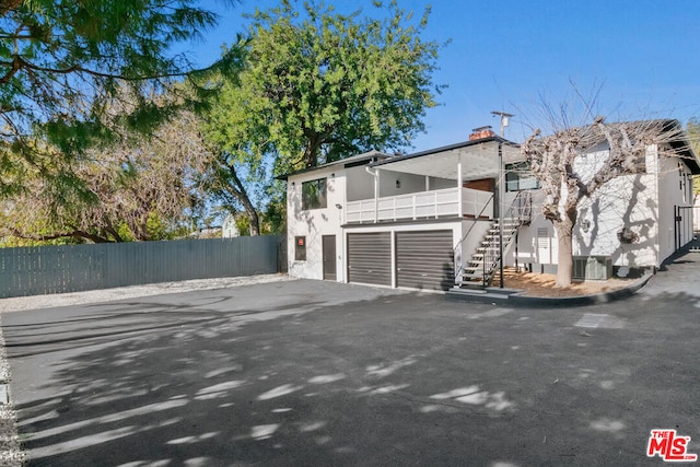 view of home's exterior featuring a garage and a balcony