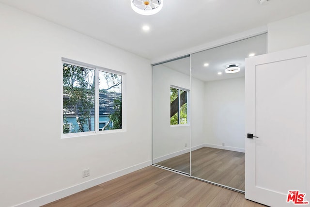 unfurnished bedroom with hardwood / wood-style flooring and a closet